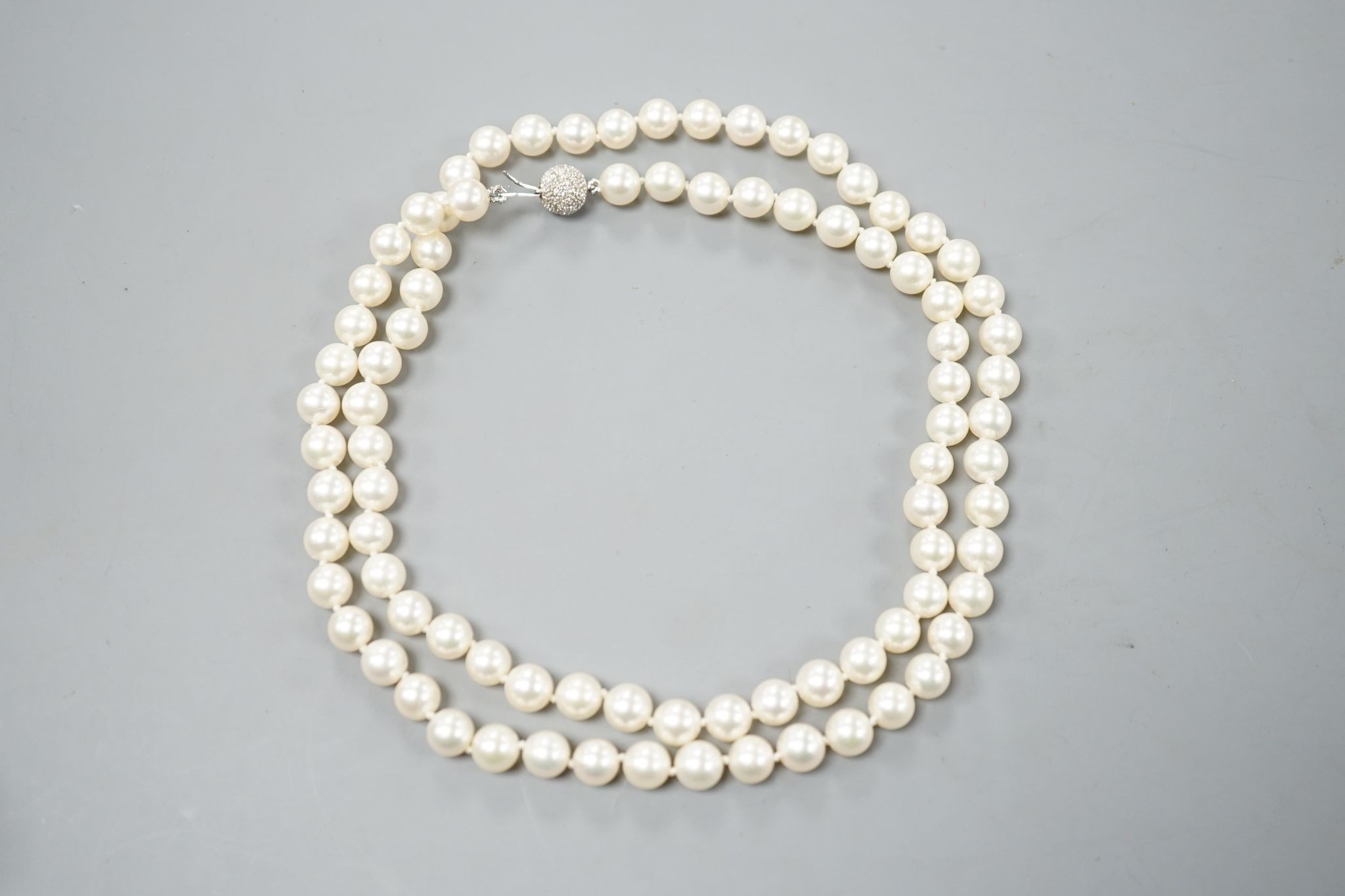 A modern single strand cultured pearl necklace, with diamond chip set spherical clasp, 72cm.